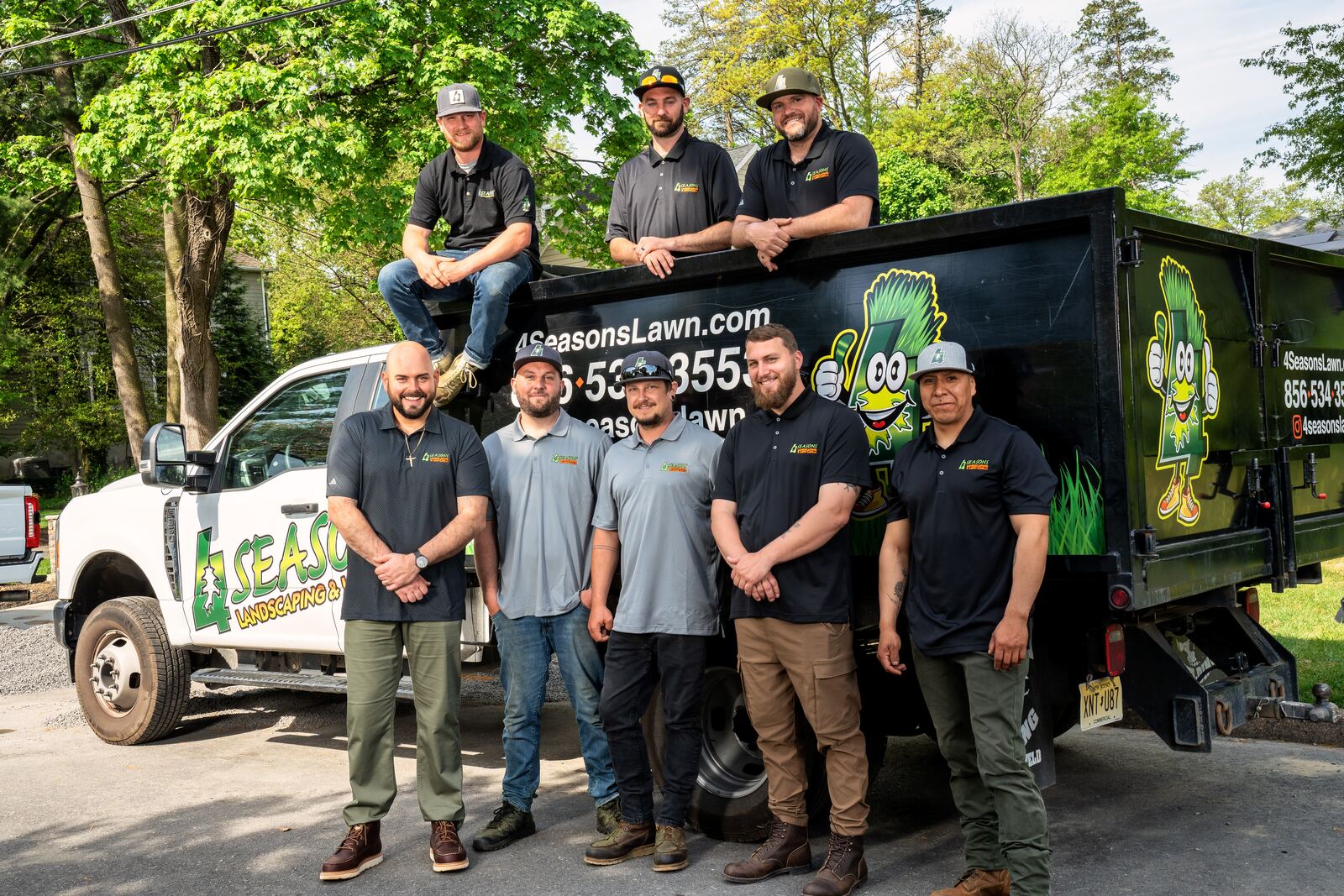 4 Seasons Lawns crew members gathered on and beside a branded company truck