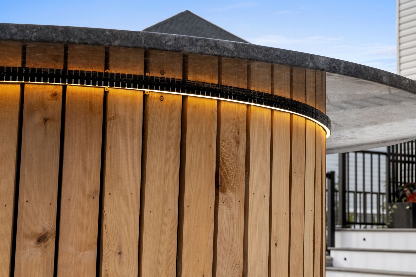 Lighting tucked under the counter edge of a cedar-clad outdoor kitchen