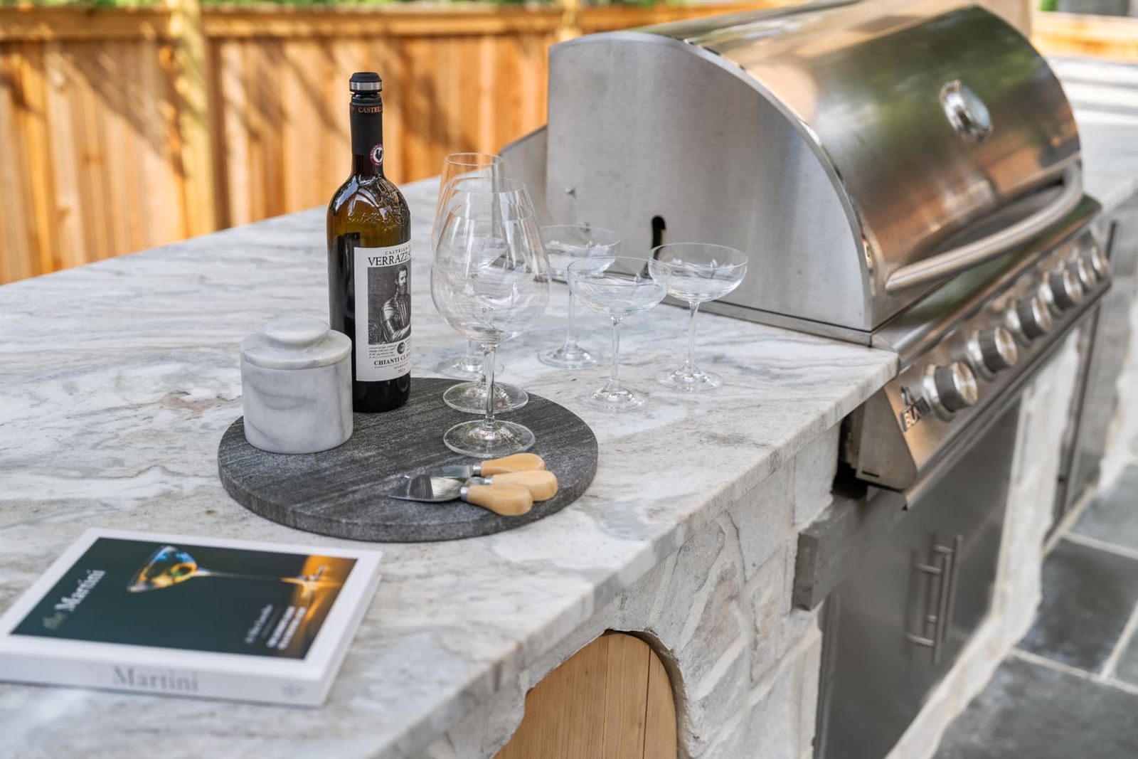 Close-up of a stone kitchen counter beside a stainless steel grill
